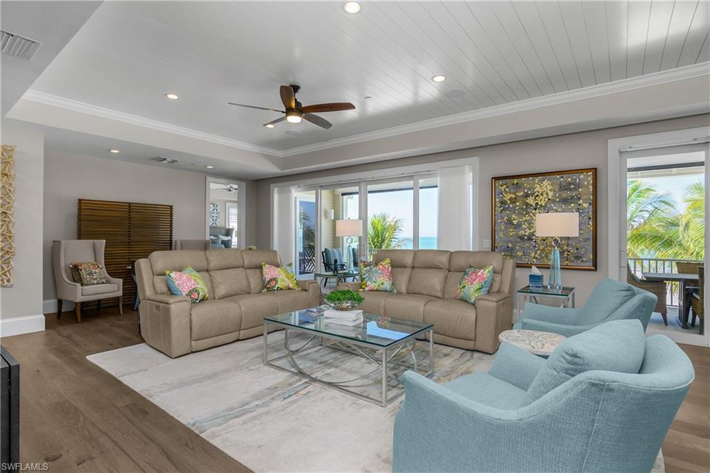 Living room featuring wood finished floors, a ceiling fan, crown molding, and recessed lighting