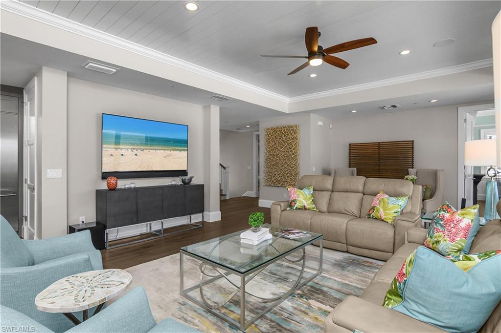 Living area featuring wood finished floors, ceiling fan, ornamental molding, and recessed lighting