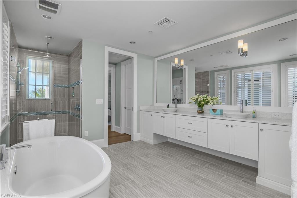 Bathroom with a shower stall, a freestanding tub, double vanity, and wood tiled floors