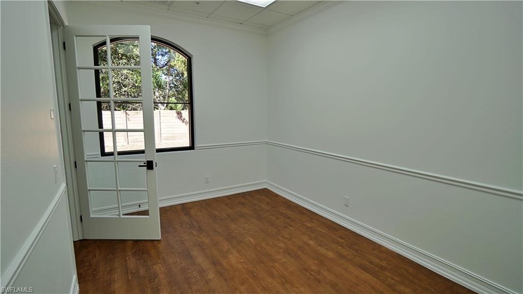 Spare room with dark wood finished floors and ornamental molding