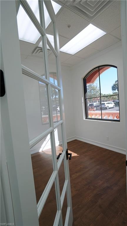 Unfurnished room with dark wood-style floors and a drop ceiling