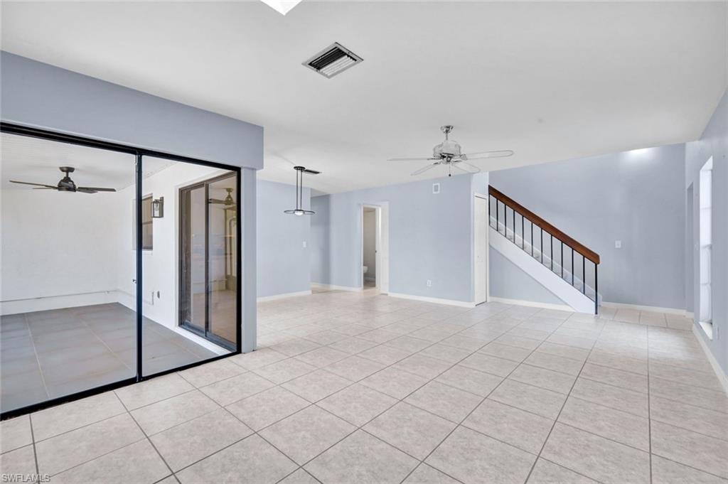 Unfurnished living room with ceiling fan and light tile patterned floors