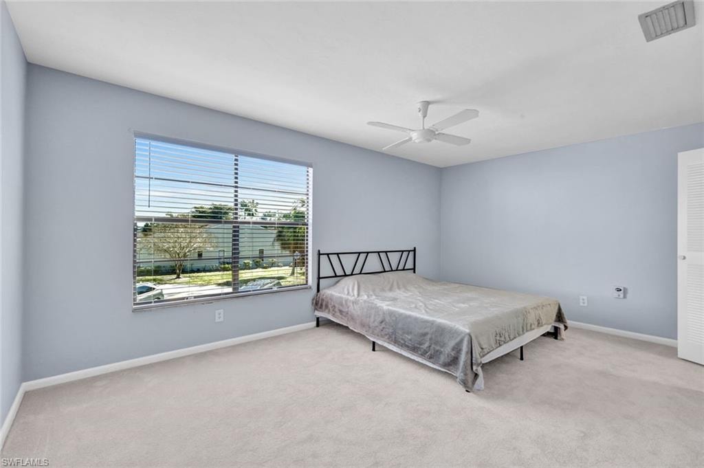 Bedroom with light carpet and ceiling fan