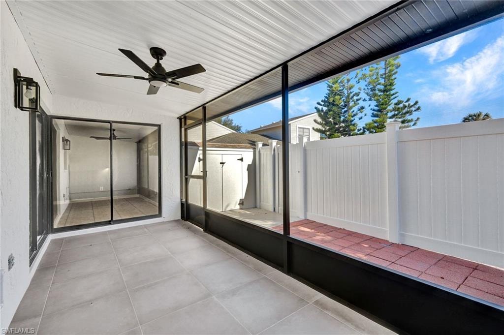Unfurnished sunroom featuring ceiling fan