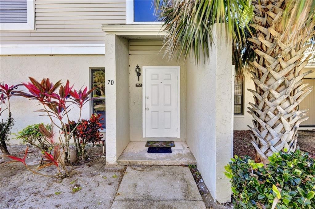 Property entrance featuring stucco siding