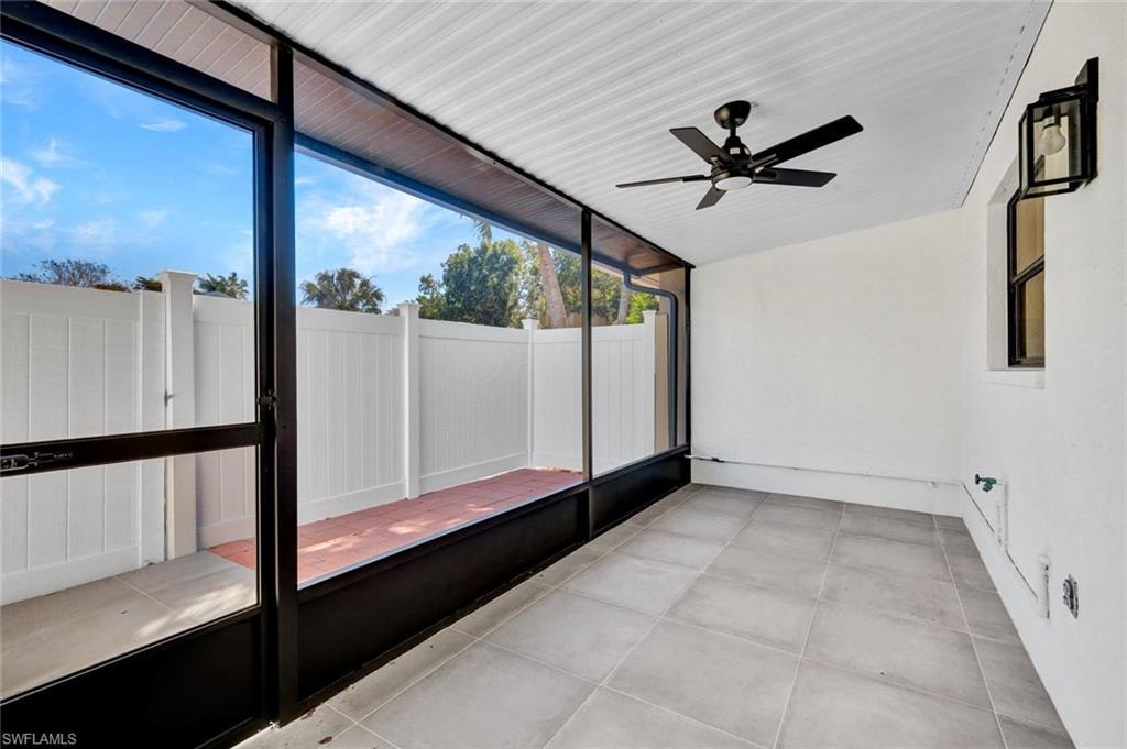 Unfurnished sunroom featuring ceiling fan