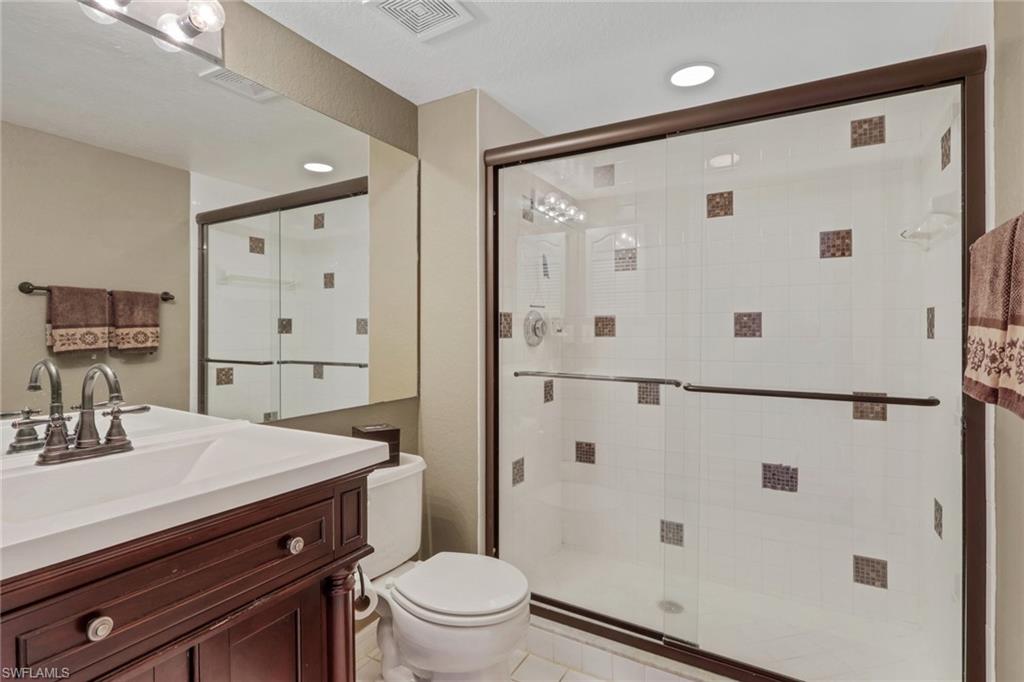 Primary bath with vanity and shower with tile accents