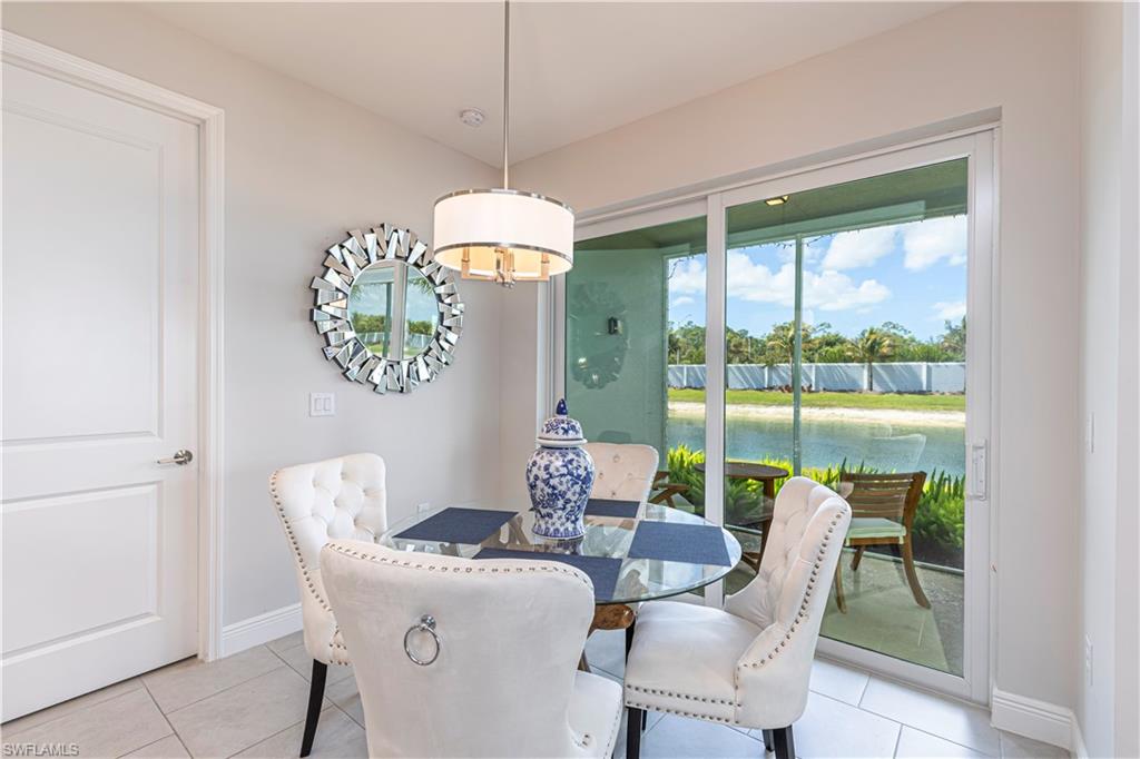 Dining space featuring light tile patterned flooring & water view