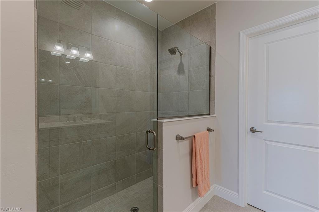 Full bathroom featuring stall shower and baseboards