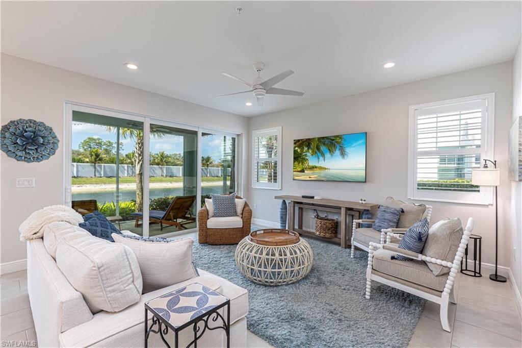 Family room featuring plenty of natural light, ceiling fan, light tile patterned floors & recessed lighting