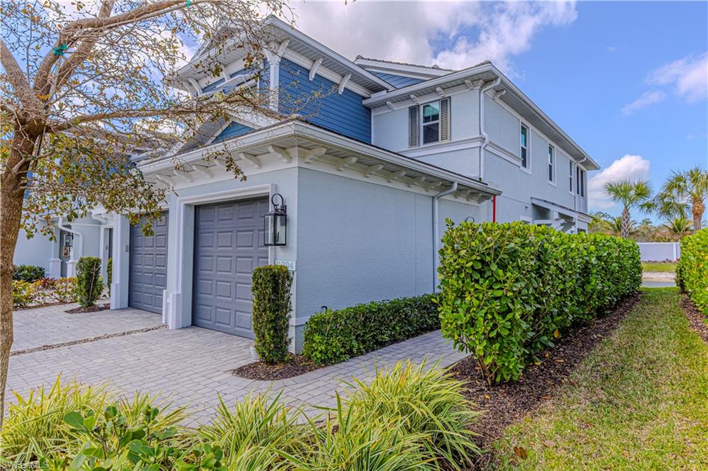 View of property exterior featuring garage & decorative driveway