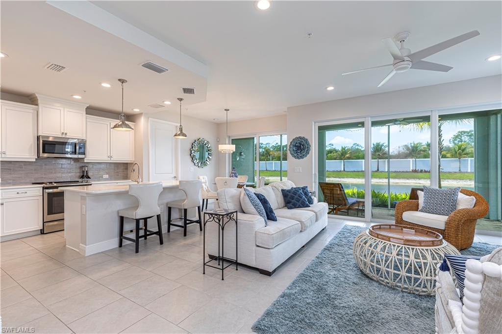 Family room featuring ceiling fan, recessed lighting, light tile patterned flooring, & water view