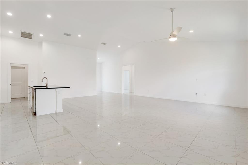 Unfurnished room with sink, high vaulted ceiling, and ceiling fan