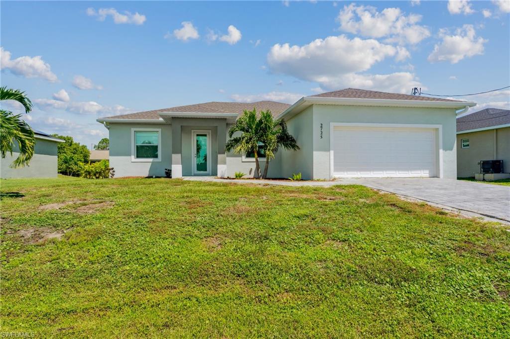 View of front of house with a front yard and a garage