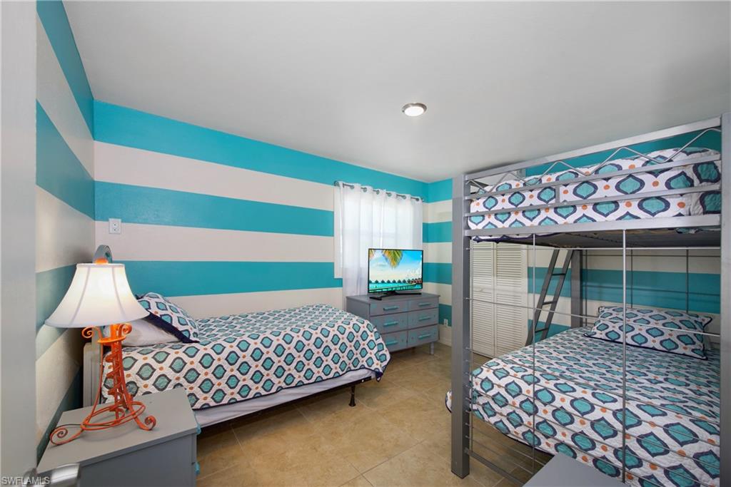 View of tiled bedroom: Functional bedroom designed for shared accommodations - Virtually Edited Image