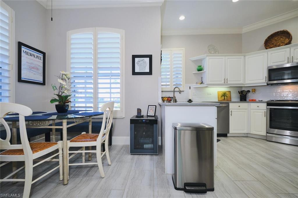 Kitchen featuring stainless steel appliances, white cabinetry, beverage cooler, open shelves, and crown molding