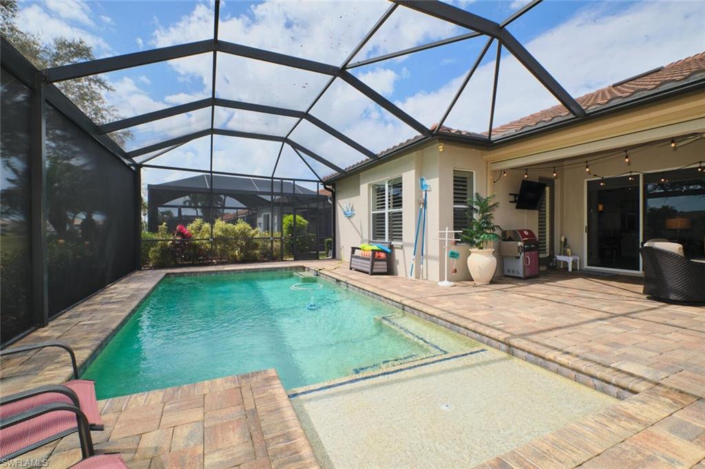 Swimming pool with a patio area, a sunroom, and a lanai