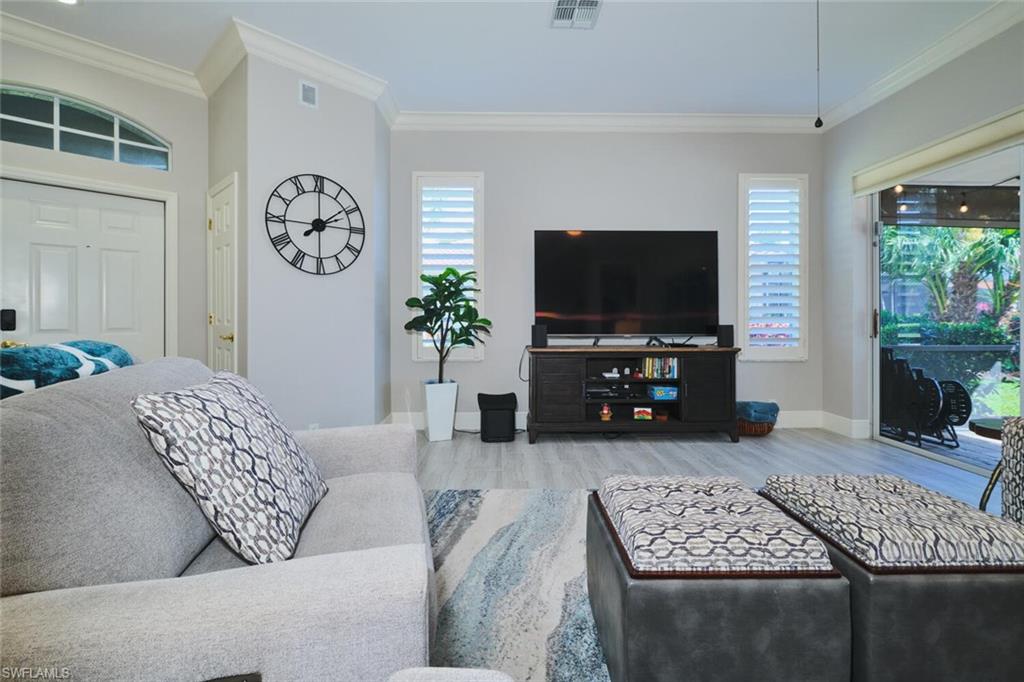 Living area featuring crown molding and light wood-type flooring