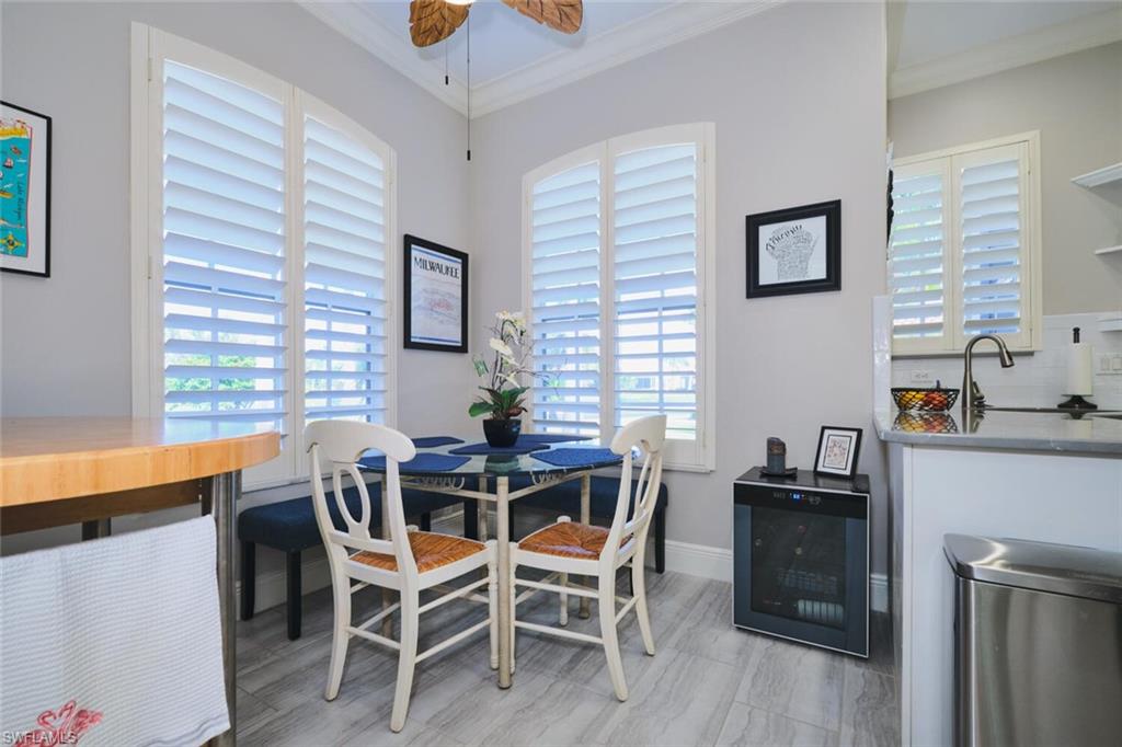 Dining room featuring wine cooler, crown molding, and a ceiling fan