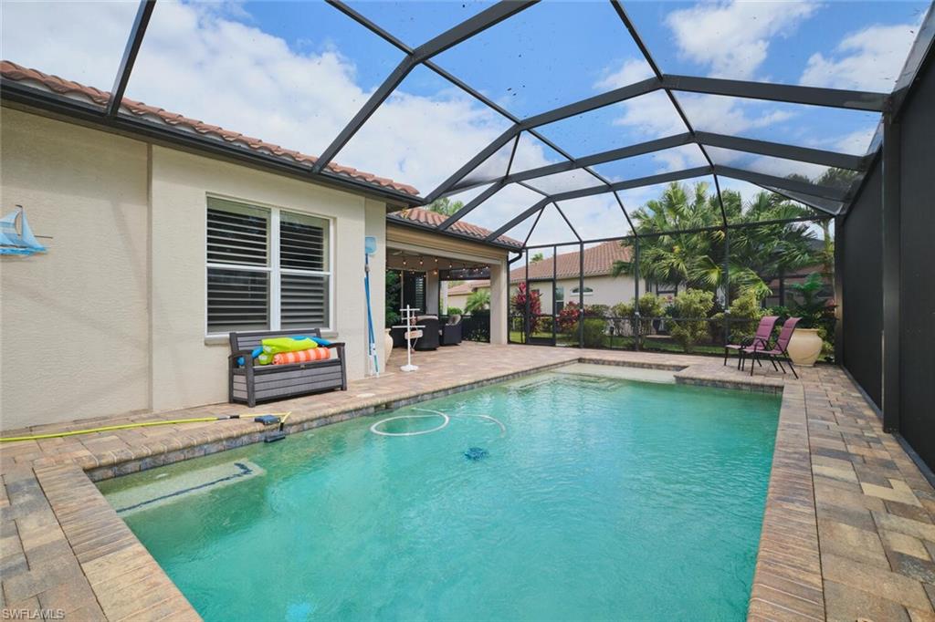 Swimming pool with a patio, a sunroom, and glass enclosure