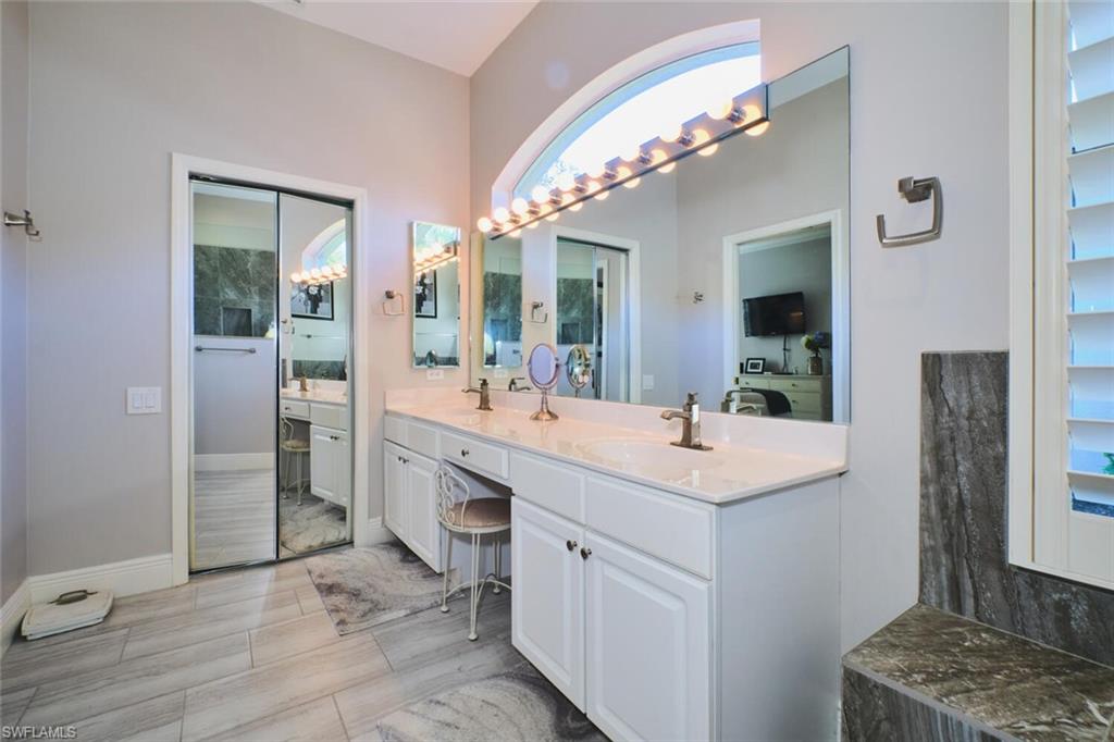 Full bath featuring double vanity and baseboards