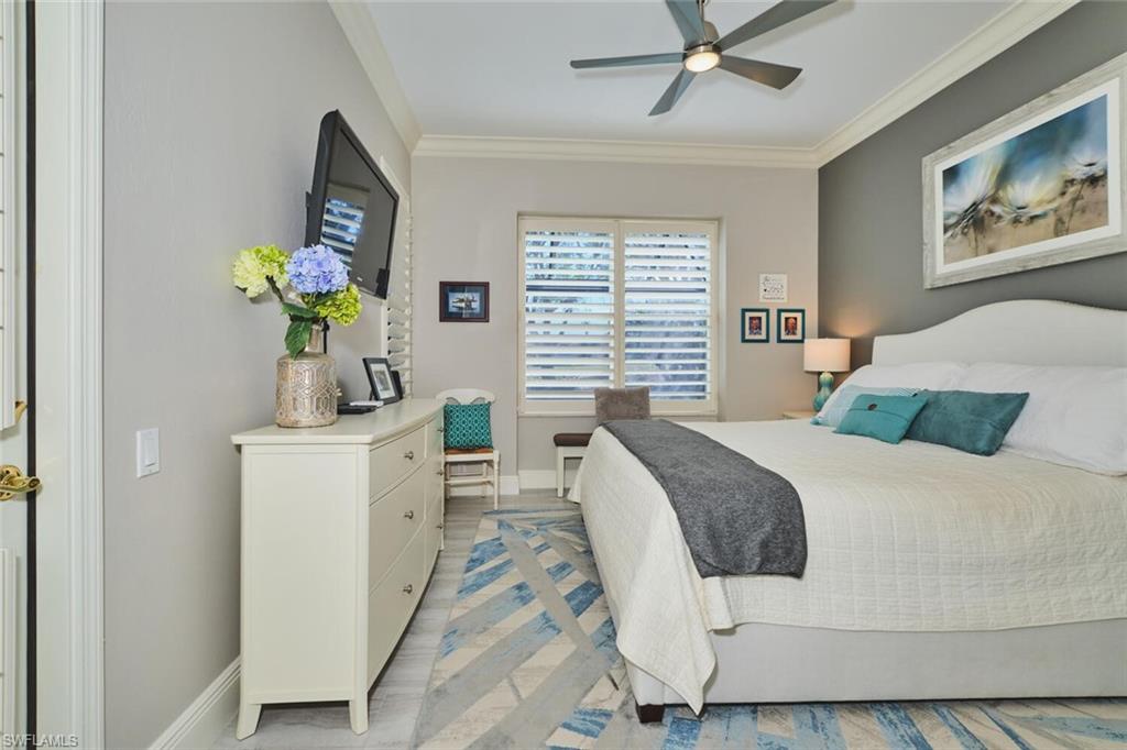 Bedroom with ornamental molding, ceiling fan, and light wood finished floors