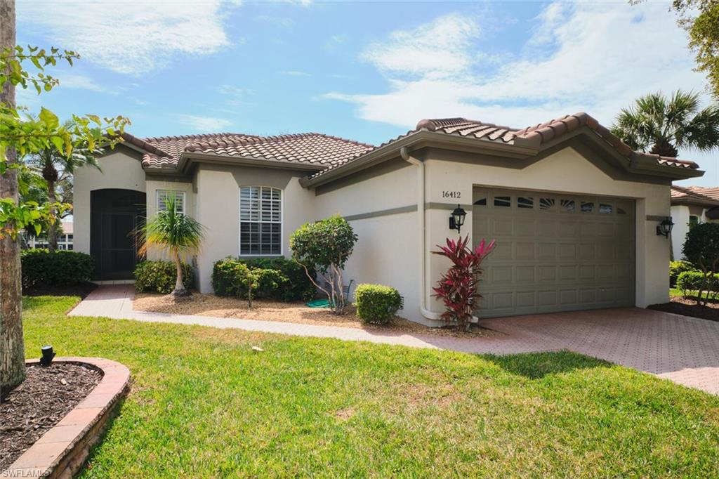 Mediterranean / spanish house featuring a front lawn, a garage, stucco siding, decorative driveway, and a tiled roof