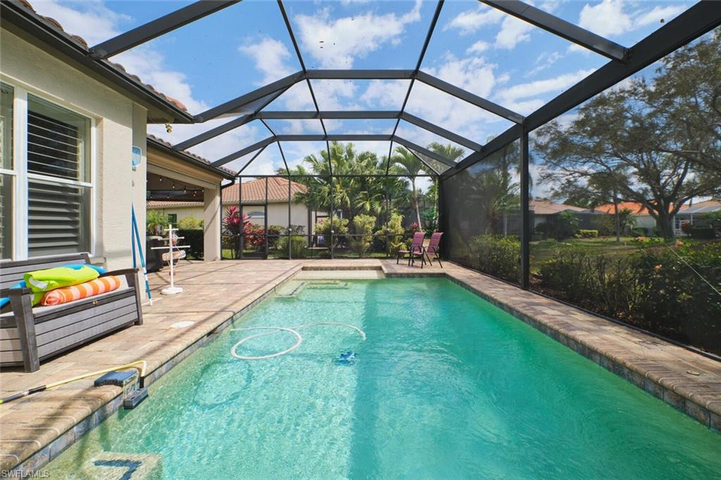 Swimming pool with a patio area, a sunroom, and a lanai