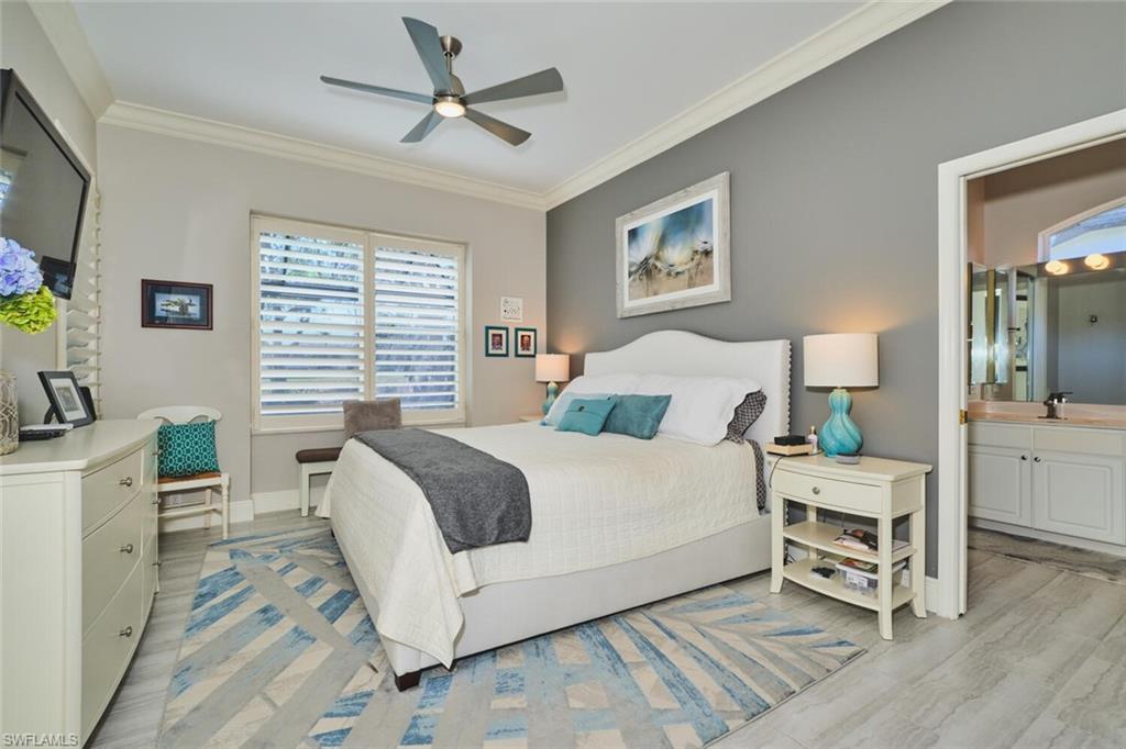 Bedroom with crown molding, ceiling fan, light wood finished floors, and connected bathroom