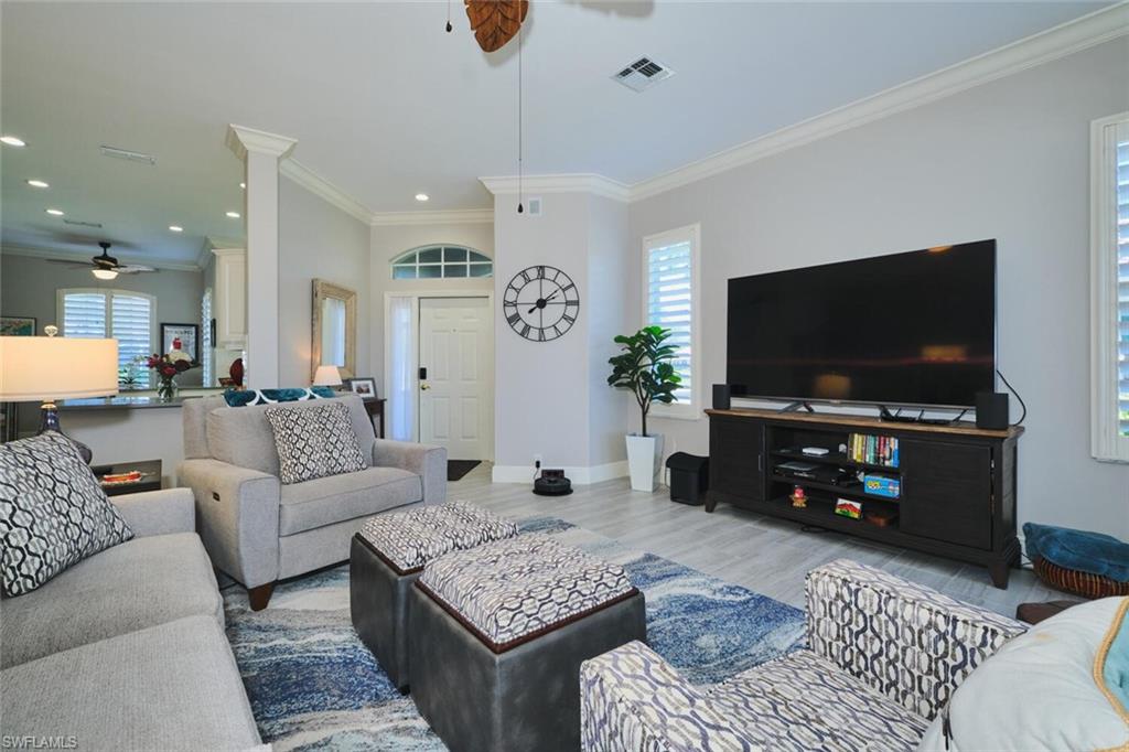 Living room with ceiling fan, wood finished floors, plenty of natural light, ornamental molding, and recessed lighting