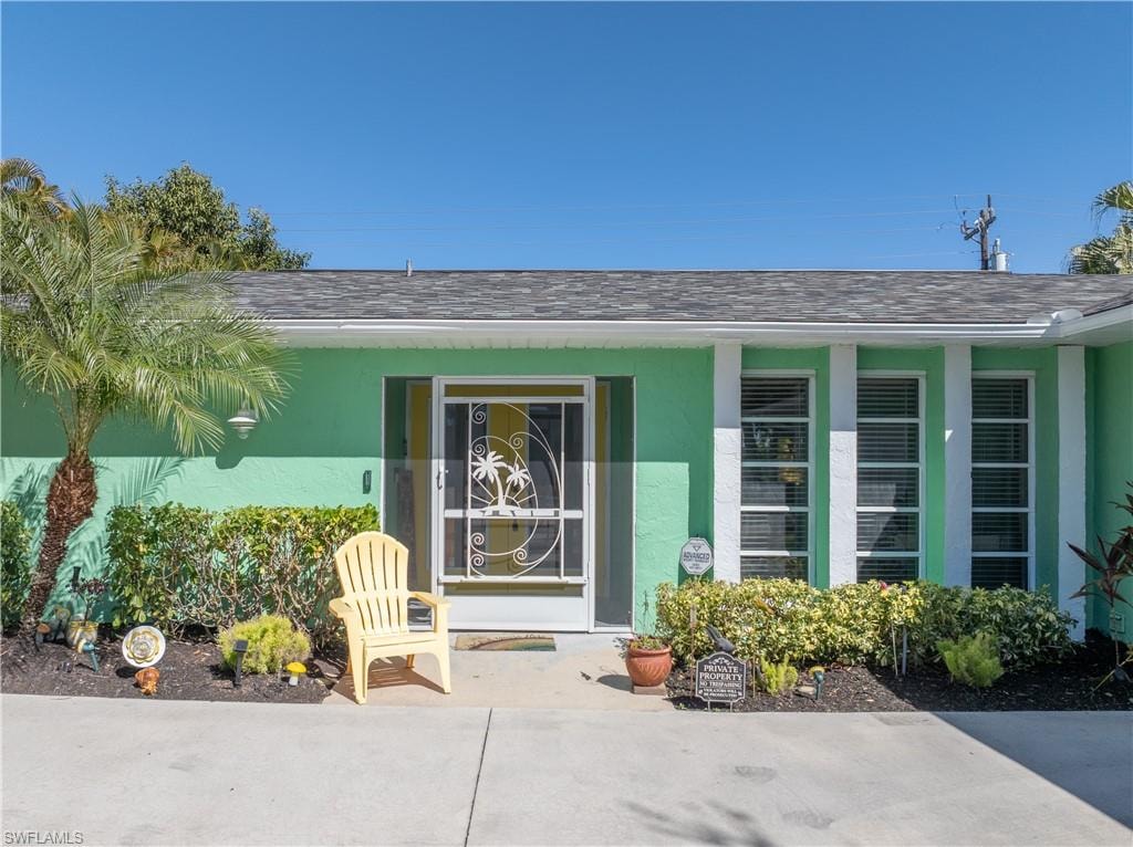 View of Front Entryway with New Custom Designed and Built Aluminum Palm Ornamental Front Foyer Screen Door and Attractive Landscaping. NOTE:  Newly Installed Rain Gutters..... AND NEW PVC Water Pipes!!.... AND Reinsulated Attic along with Sealed UP Air Handler.
