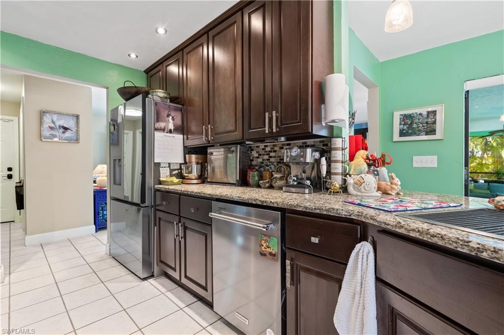 View of Granite Kitchen with High End Stainless Appliances, Crown Molded Cabinetry to Ceiling [Note attractive Designer Cabinetry Hardware] w/Deep Stainless Farmhouse Sink with Rollback Drainboard, Pot Filler and Built In Soap Dispenser and Accessories.