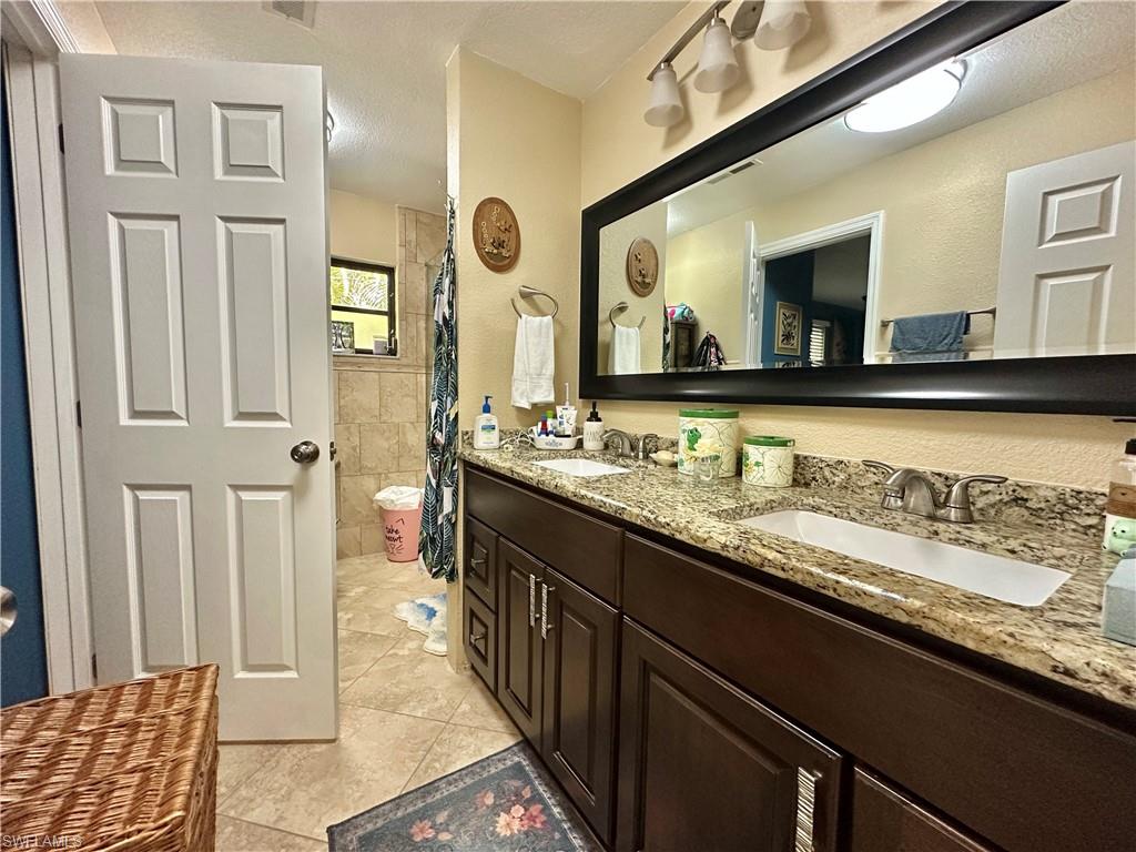 View of the Eastside Bath with Granite, Designed Hardware, Large Framed Mirror, New Upgraded Decorative Tiling,  and "Heated Intelligent Toilet." [NOTE:  Doorway is from/into Eastside Ensuite]