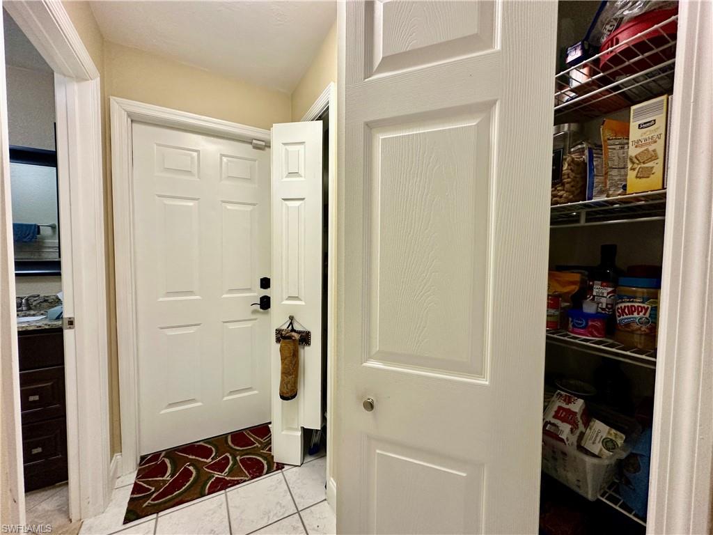 View of the "Hallway" with Two Shelved Closets [one used as Pantry and Second used as Linen/Storage]. View also doorway to the Side Load Two Car Garage and Laundry and Left Doorway to the East Ensuite Bathroom.