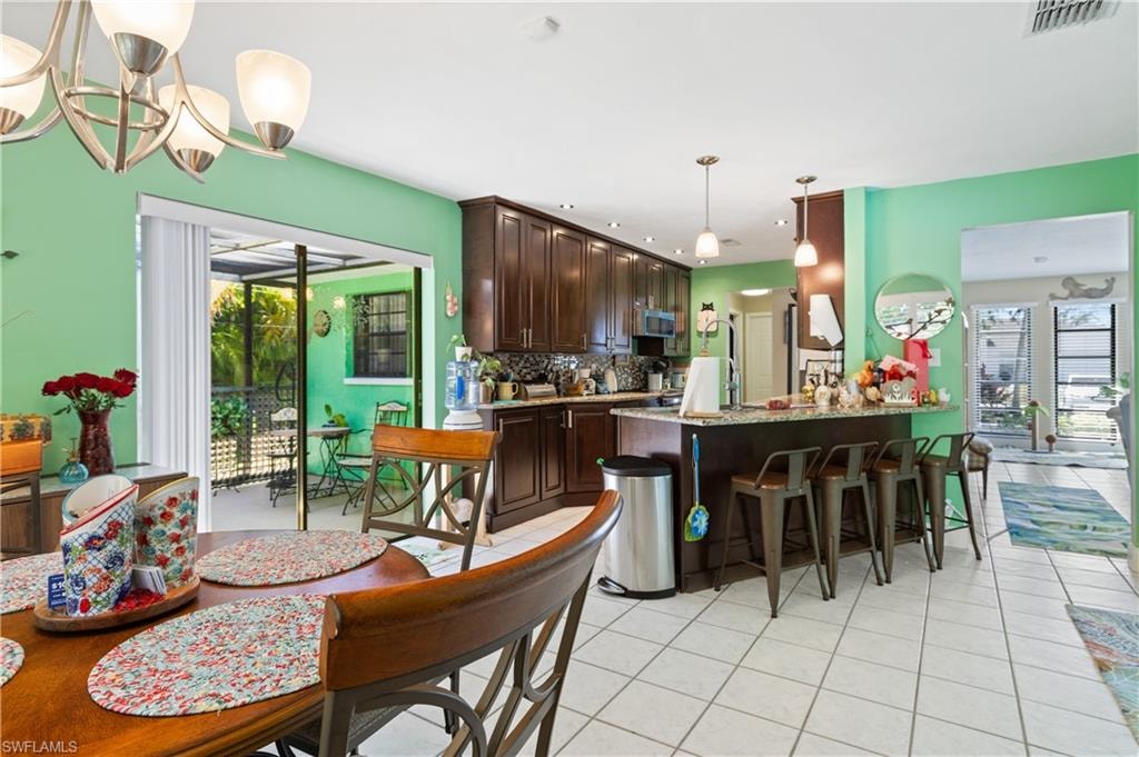 Attractive View from Dining Room to High End Efficient Granite/High End Stainless Appliance Packaged Kitchen  with Breakfast Bar. [Note Slider to Privacy Mansard Caged Spa]