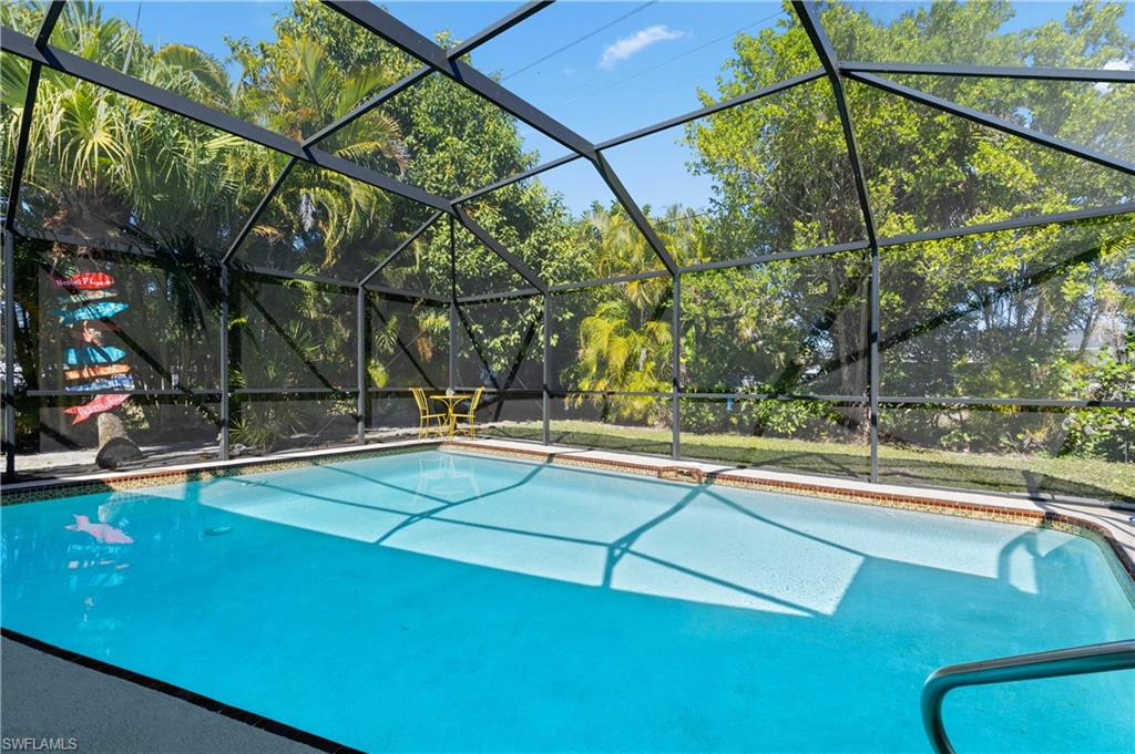 View of Pool with New Screened Pool Cage and Newly Landscaped/Mulched Rear Yard. [w/Newly Installed Water Timing Systems for both Pool and Spa]