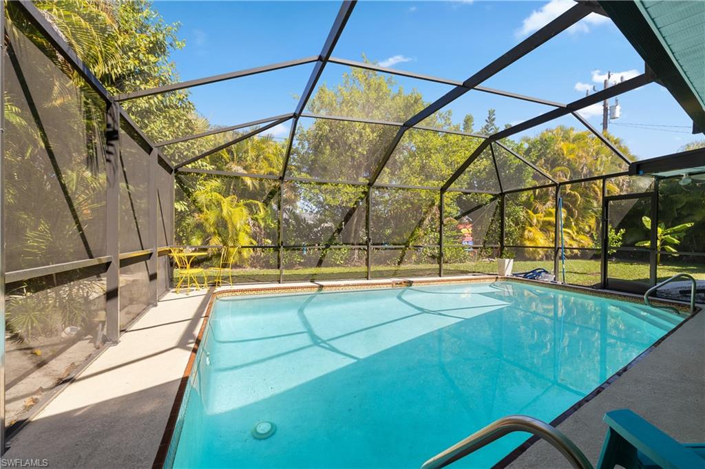 View of Crystal Clear Pool with New Screened Pool Cage and New Electric Pool Heater... with Newly Installed Water Timing System and New Filtration/Pump for Both Pool and Spa. [Deck was repaired with loose grout and tiles around both pool and spa.