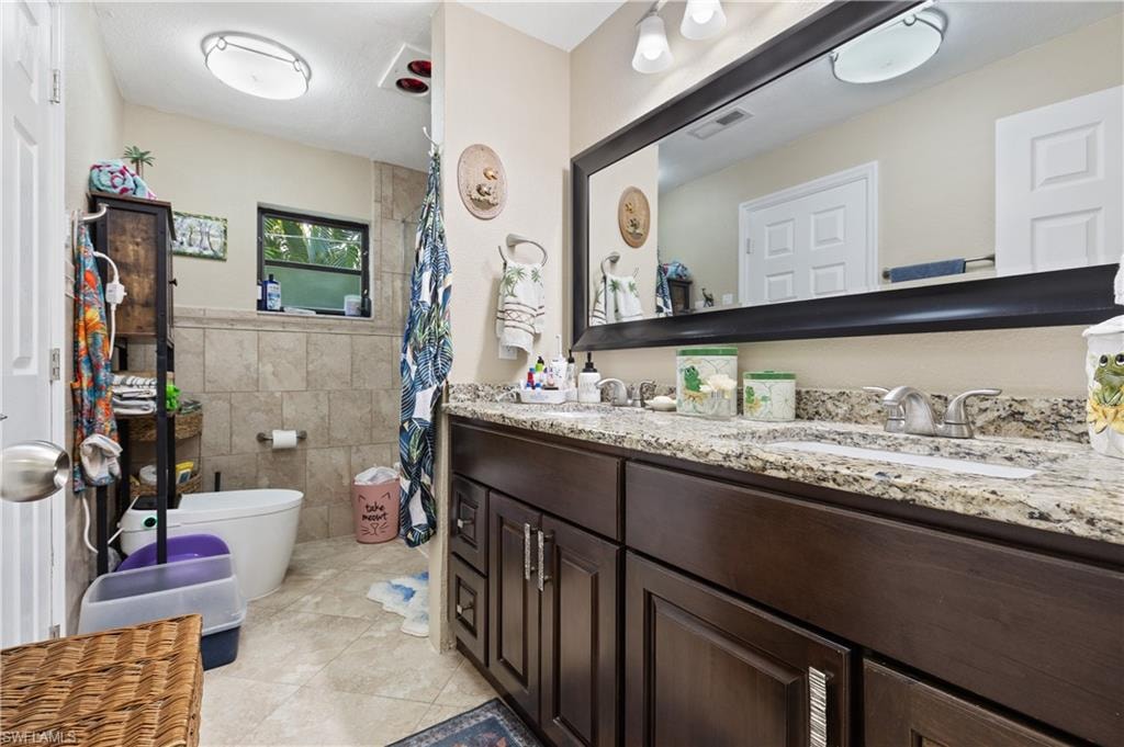 View of the Eastside Bath Glass Doored Combo Tub/w/Handheld Shower with Decorative Tiling to ceiling, with two InCut Shelving and "Heated Intelligent Toilet."