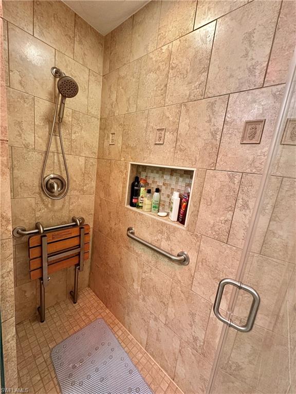 View of Westside Huge Tiled Floor to Ceiling with Cut In Shower w/Pull Down Seat, New Moen Hand-Held Hardware and Glass Doored.