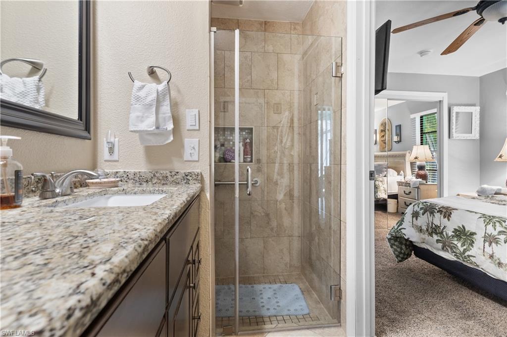 View of West Side Ensuite Granite Bath with New Floor to Ceiling Tiled, Glass Doored Walk In Shower. with Cut In.  NOTE the same high end Vanity/ Designer Hardware with Framed Mirrow AND AND Newly Installed Fan, Lighting and HEAT LAMPS.