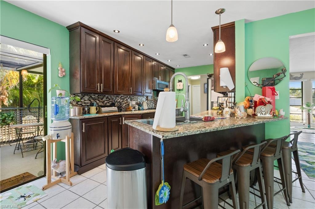 View of Slider to the Privacy Spa and Granite/Tiled Splashguard Kitchen with Crown Molding Topped Cabinetry and its Breakfast Bar. [Note right Doorway to Sunlit Living Room and the Designer Cabinetry Hardware] ... AND Under Cabinetry Remote Controlled Lighting!!