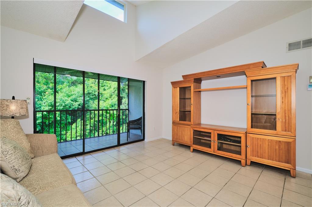 Great room features tile floors, vaulted ceilings, triple sliders.