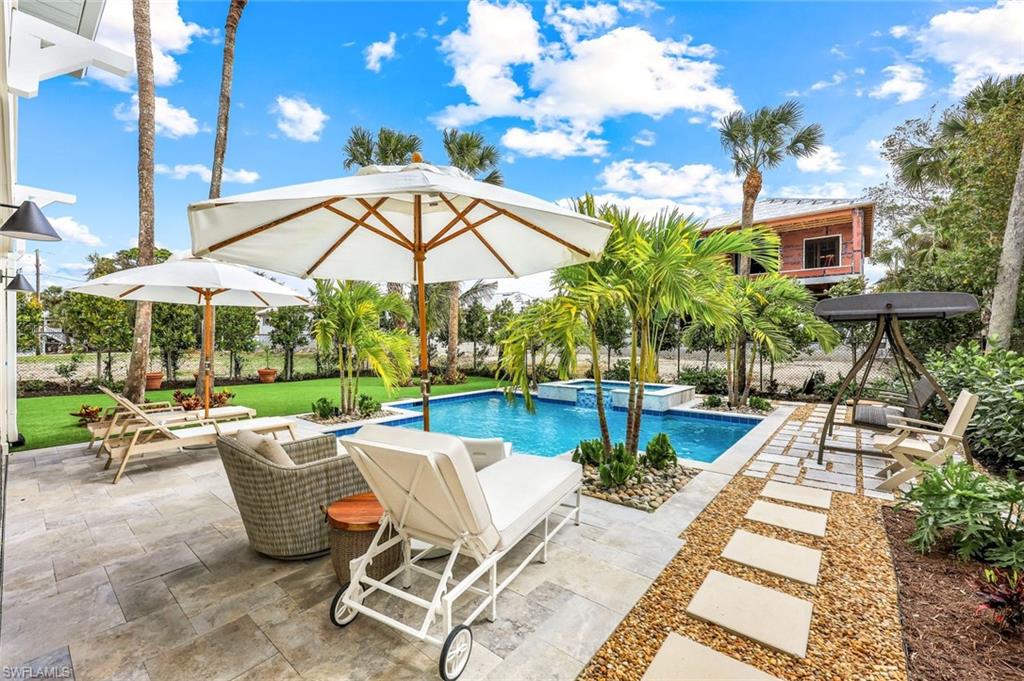 View of swimming pool with a patio, a yard, and a pool with connected hot tub