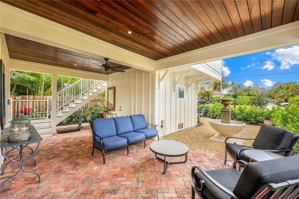 View of patio featuring stairway, ceiling fan, outdoor lounge area, and fence