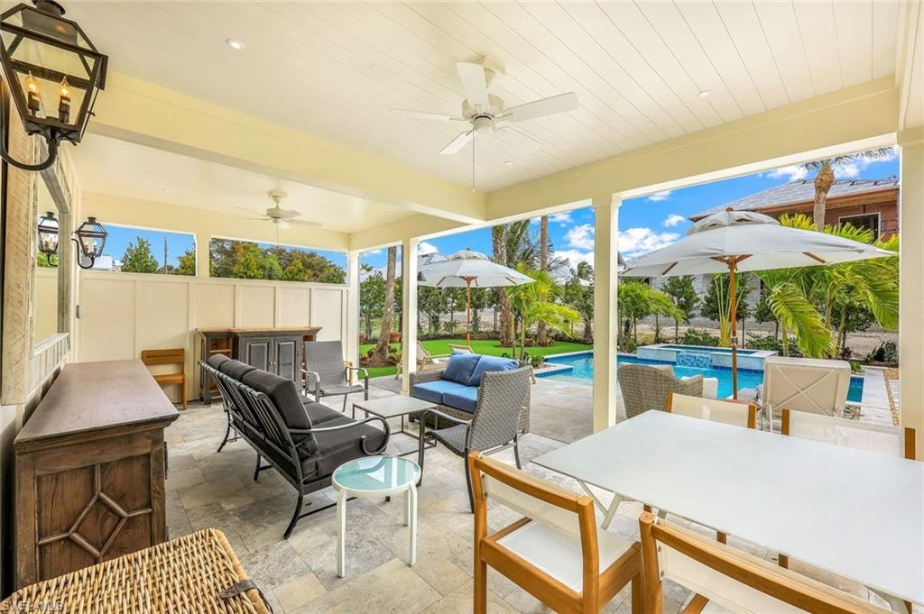 View of patio / terrace featuring outdoor lounge area, outdoor dining space, a ceiling fan, and a pool with connected hot tub