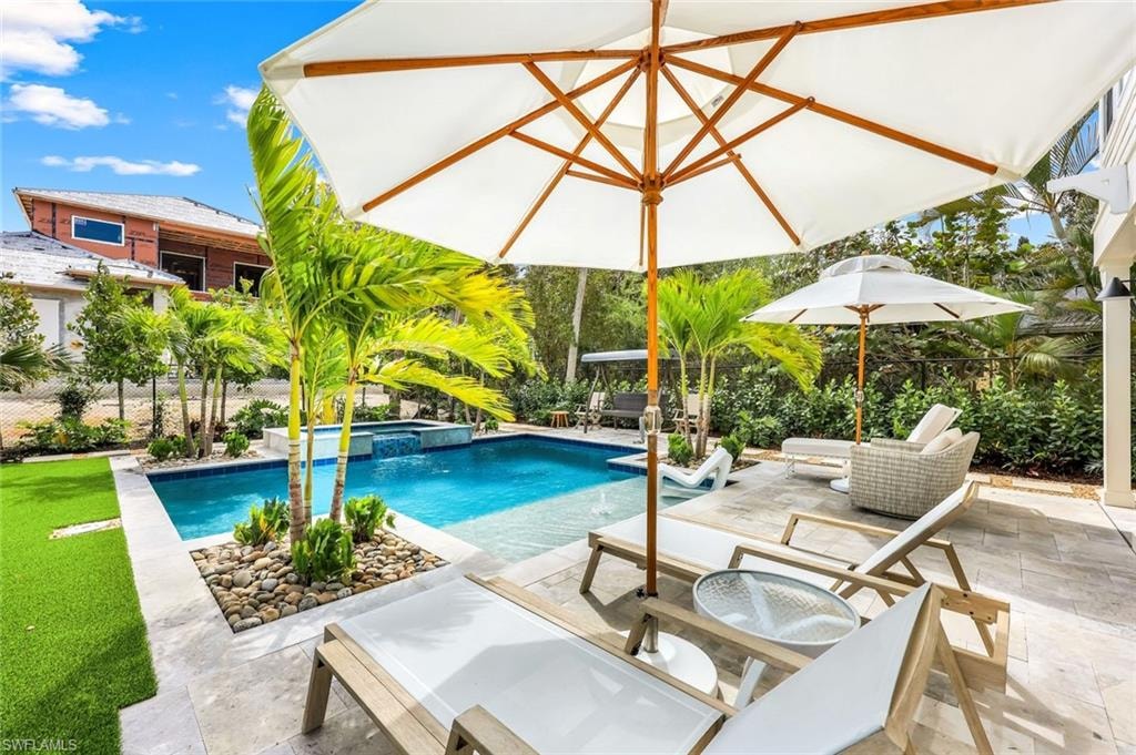 View of pool featuring a pool with connected hot tub and a patio area