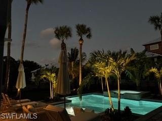 View of swimming pool featuring a patio and a pool with connected hot tub