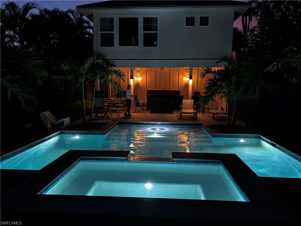 View of swimming pool with outdoor dining space, a patio, and a pool with connected hot tub