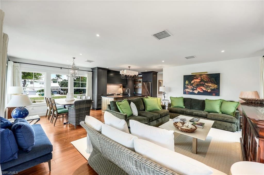 Living room featuring recessed lighting, visible vents, a chandelier, and light wood-type flooring
