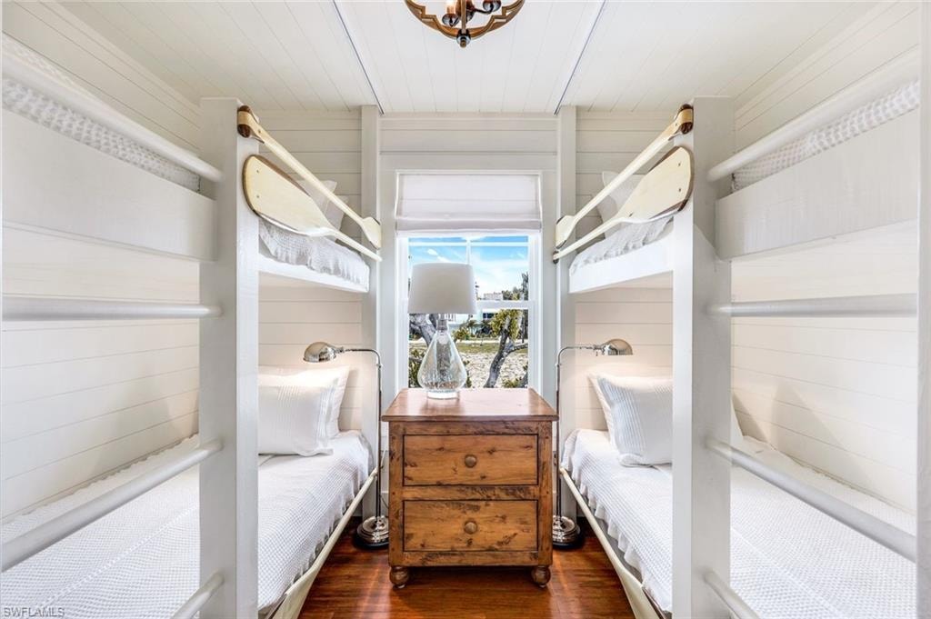 Bedroom featuring wood finished floors and wood walls